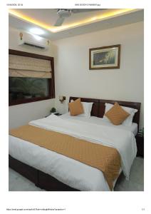 een slaapkamer met een groot bed met witte lakens bij YANA B&B in New Delhi