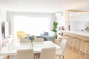 uma cozinha e sala de estar com mesa e cadeiras em New cosy house, close to shoppong center em Hamilton