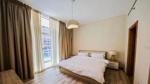 a bedroom with a bed and a large window at Living in a Tower in Downtown - Extravagance at a Budget Price - Only 5 Minutes’ Walk to Dubai Mall in Dubai