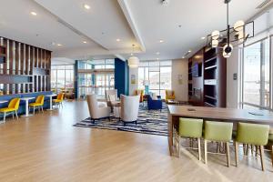 Comfort Inn & Suites at Sanford Sports Complex في شلالات سيوكس: لوبي مع طاولة وكراسي في مبنى
