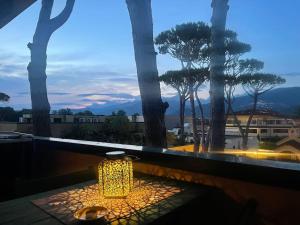 a light on a table with a view of trees at MiniJungleSuite close to the Sea in Cinquale
