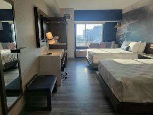 Cambria Hotel Niagara Falls في شلالات نياغارا: غرفة فندقية بسريرين ونافذة