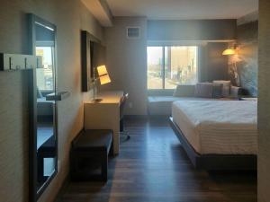 Cambria Hotel Niagara Falls في شلالات نياغارا: فندق صغير غرفه بسرير واريكه