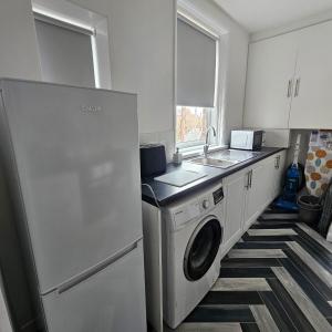 a kitchen with a washing machine and a sink at Lyndhurst Terrace, Sunderland in Trimdon Grange