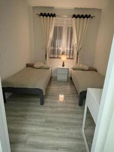 pokój z 2 łóżkami i lampką w obiekcie Apartament na Miłej w mieście Kostrzyn nad Odrą