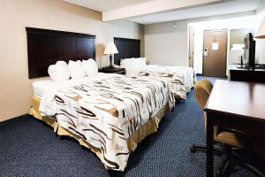 a hotel room with two beds and a desk at Rodeway Inn in Helena