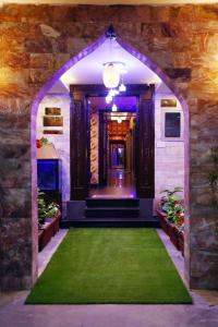 Hotel Grand Pearl في لاهور: مدخل لبيت عليه سجادة خضراء