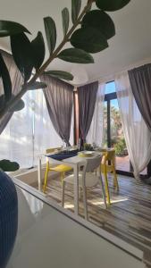 Un comedor con una mesa y sillas y un espejo. en Green Ocean House - Origo Mare, en Lajares