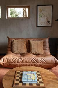 a brown leather couch with a chessboard on a table at E. Gray house in Dungarvan