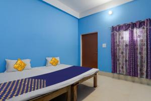 a blue room with a bed and a window at SPOT ON New Modern Guest House in Varanasi
