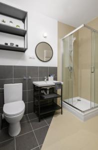 uma casa de banho com um WC, um chuveiro e um lavatório. em Student Depot Lublin Apartamenty em Lublin
