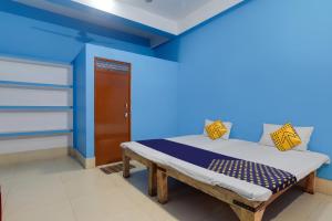 a bedroom with a bed in a blue room at SPOT ON New Modern Guest House in Varanasi