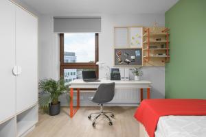 a bedroom with a desk with a laptop and a bed at Student Depot Lublin Apartamenty in Lublin
