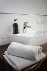 a white bathroom sink with a towel on a counter at Wattlodge in Norden