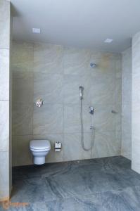 uma casa de banho com um chuveiro e um WC. em Jomo Resort em Alibag