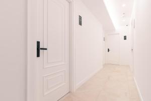 un corridoio con pareti bianche e una porta di Miramar a Ulcinj
