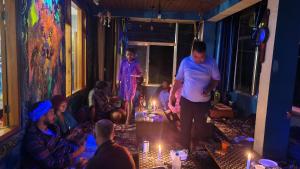 un grupo de personas en una habitación con velas encendidas en Formosa Hostel & Cafe en Kasol