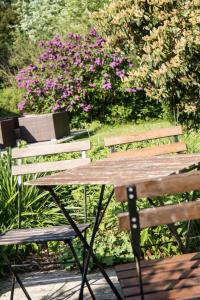 einen Picknicktisch und Bänke in einem Garten mit Blumen in der Unterkunft Wattlodge in Norden