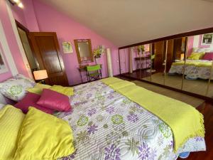 ein Schlafzimmer mit einem großen Bett mit bunten Kissen in der Unterkunft La Perla de la Riberuca - Suances in Suances