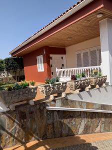 ein Haus mit Topfpflanzen auf der Veranda in der Unterkunft Holiday Home Austry in Tejina