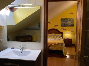 ein Bad mit einem Waschbecken und ein Bett in einem Zimmer in der Unterkunft La Perla de la Riberuca - Suances in Suances
