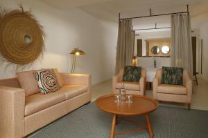 a living room with a couch and two chairs and a table at Praia do Canal Nature Retreat in Aljezur