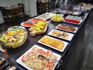 un buffet con muchos tipos diferentes de comida en una mesa en Hotel Euro Moniz, en Porto Moniz