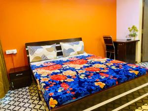 a bedroom with a bed with a blue blanket with flowers at Private 1Bedroom AC Kalyani Nagar Pune Close to Osho Garden Koregaon Park in Pune