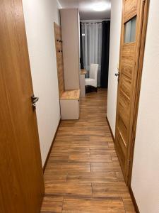 a hallway with an open door to a room with a wooden floor at Pokoje nad stawem in Rozogi