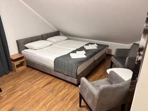 una camera con un letto e una sedia di BIAŁY DOM - Pokoje do wynajęcia a Rozogi Altre 17 foto