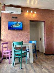 uma sala de jantar com cadeiras coloridas e uma mesa em Apartmani Peko em Vodice