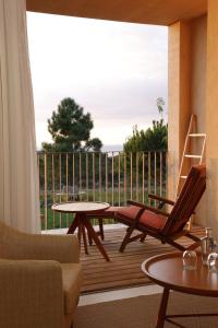 a patio with a table and a chair and a table at Praia do Canal Nature Retreat in Aljezur