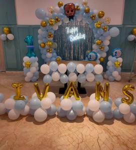 a table with white balloons and a happy birthday sign at HOTEL MAX in New Delhi