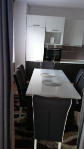 a dining room with a table and chairs and a kitchen at House Otes Ilidža in Sarajevo