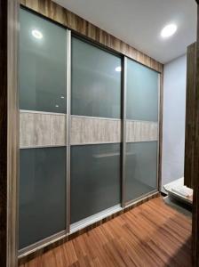 Habitación con puertas de cristal y suelo de madera. en 1717 Bintulu Homestay 11 en Bintulu