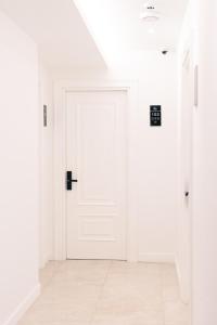 Una puerta blanca en una habitación blanca con suelo de baldosa. en Miramar, en Ulcinj