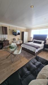 um quarto com uma cama, uma mesa e um sofá em Halfway Gardens Home em Midrand