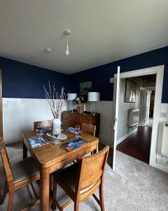 a dining room with a wooden table and chairs at Machair House in Iona