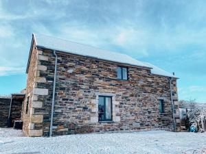 un edificio de ladrillo con dos ventanas en la nieve en MEILA COTTAGE LUXURY COASTAL RETREAT, en Cubert