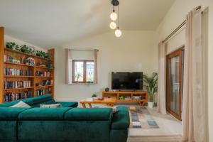 uma sala de estar com um sofá verde e uma televisão em Villa Alora em Pridraga