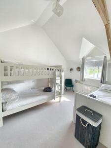 1 dormitorio blanco con 2 literas y ventana en MEILA COTTAGE LUXURY COASTAL RETREAT, en Cubert