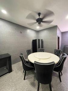 a room with a table and chairs and a ceiling fan at 1717 Bintulu Homestay 11 in Bintulu