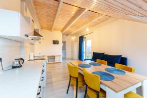 cocina y comedor con mesa de madera y sillas en Nadmorski apartament XXIV by Holiday&Sun, en Grzybowo