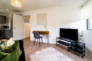 ein Wohnzimmer mit einem TV und einem Tisch in der Unterkunft Comfy One BR | Free Parking in Taunton