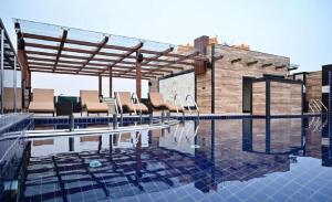 een zwembad met stoelen bovenop een gebouw bij AGM GRAND HOTEL & Spa in Digha