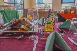 a table with a plate of food and wine glasses at Sportsview Hotel Kasarani in Nairobi