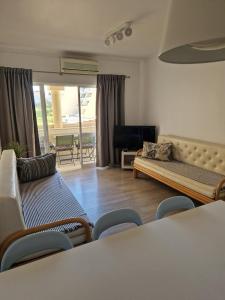 um quarto com uma sala de estar com um sofá e cadeiras em Apartamento T2 Palmeira Galé-Praia da Galé na Guia