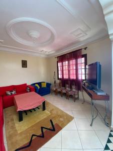 een woonkamer met een rode bank en een tafel bij villa à souiriya kdima in Safi