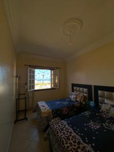 um quarto com 2 camas e uma janela em villa à souiriya kdima em Safi