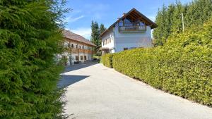 einen Weg vor einem Haus mit Hecke in der Unterkunft Gästehaus Lanthaler in Rosenbach